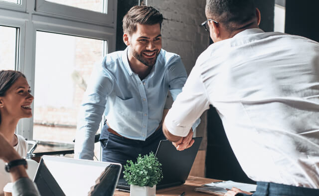 Glad recruiters shaking hands and offering the opportunity of building a new innovative carrier to a new creative employee